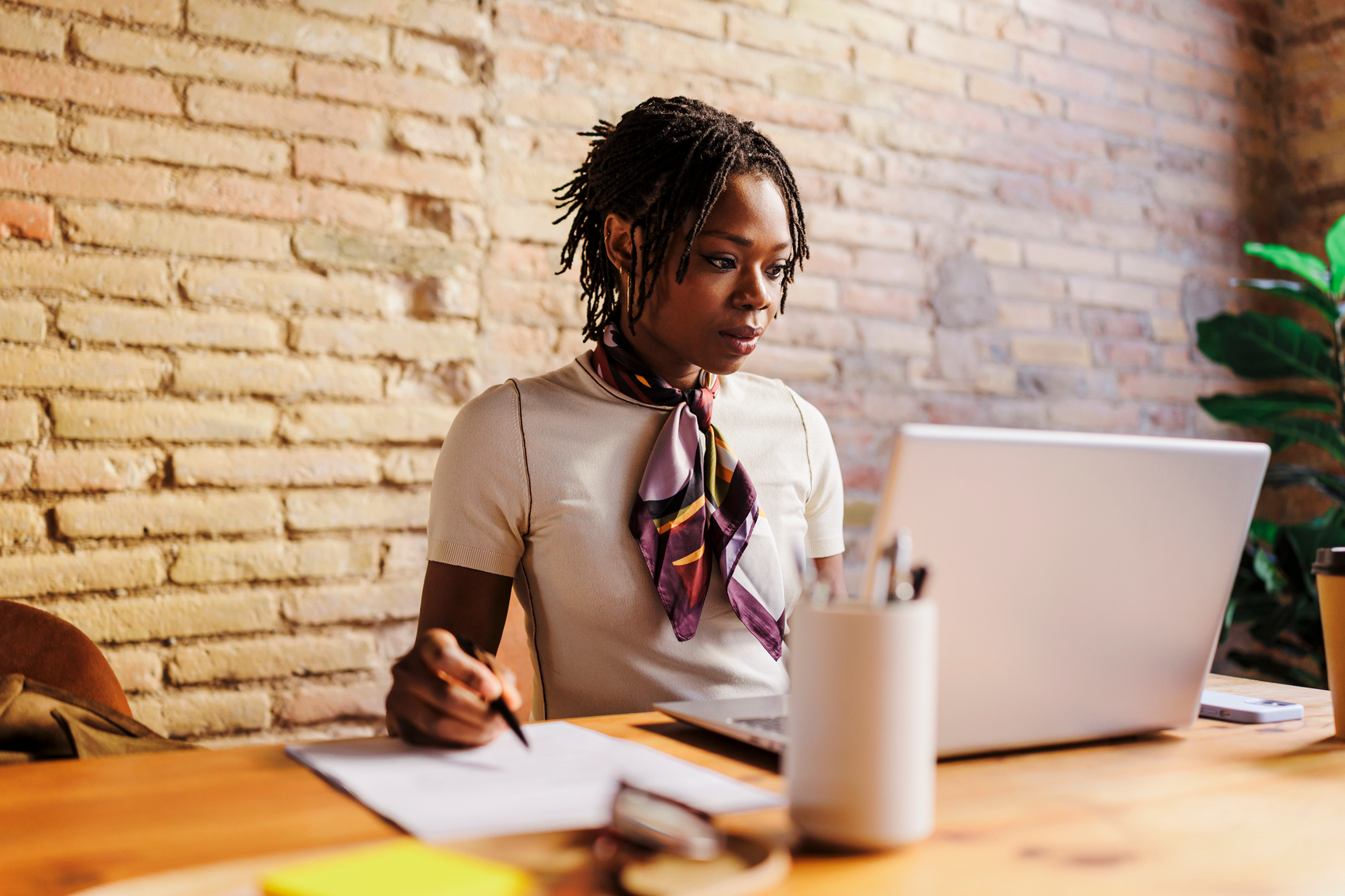 A person working with a laptop and notes