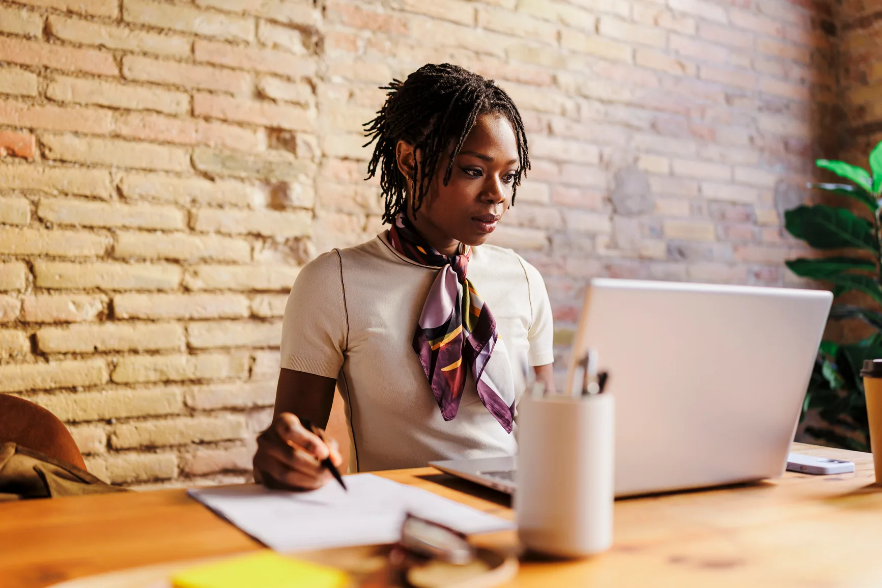 A person working with a laptop and notes